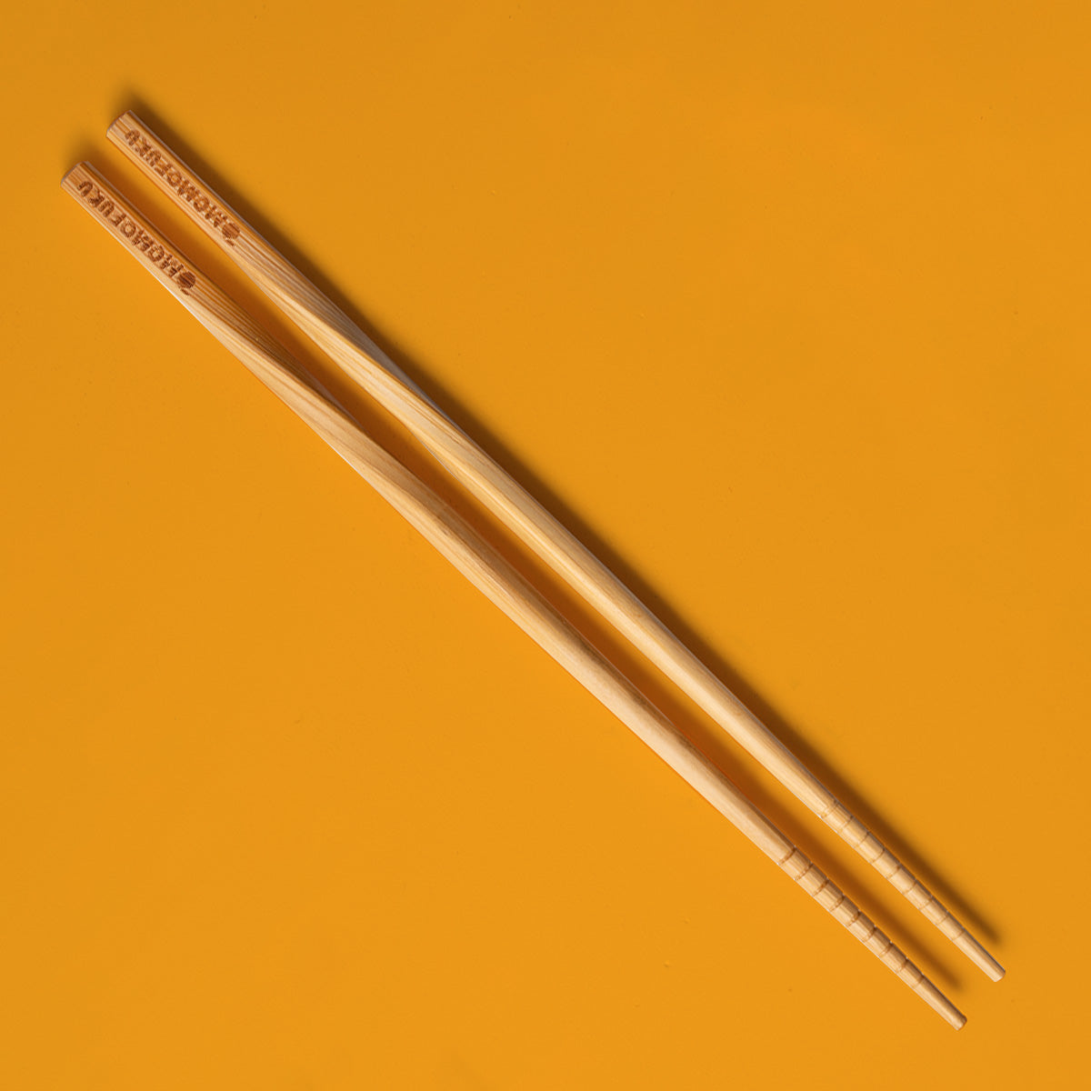 pair of momofuku chopsticks on orange background