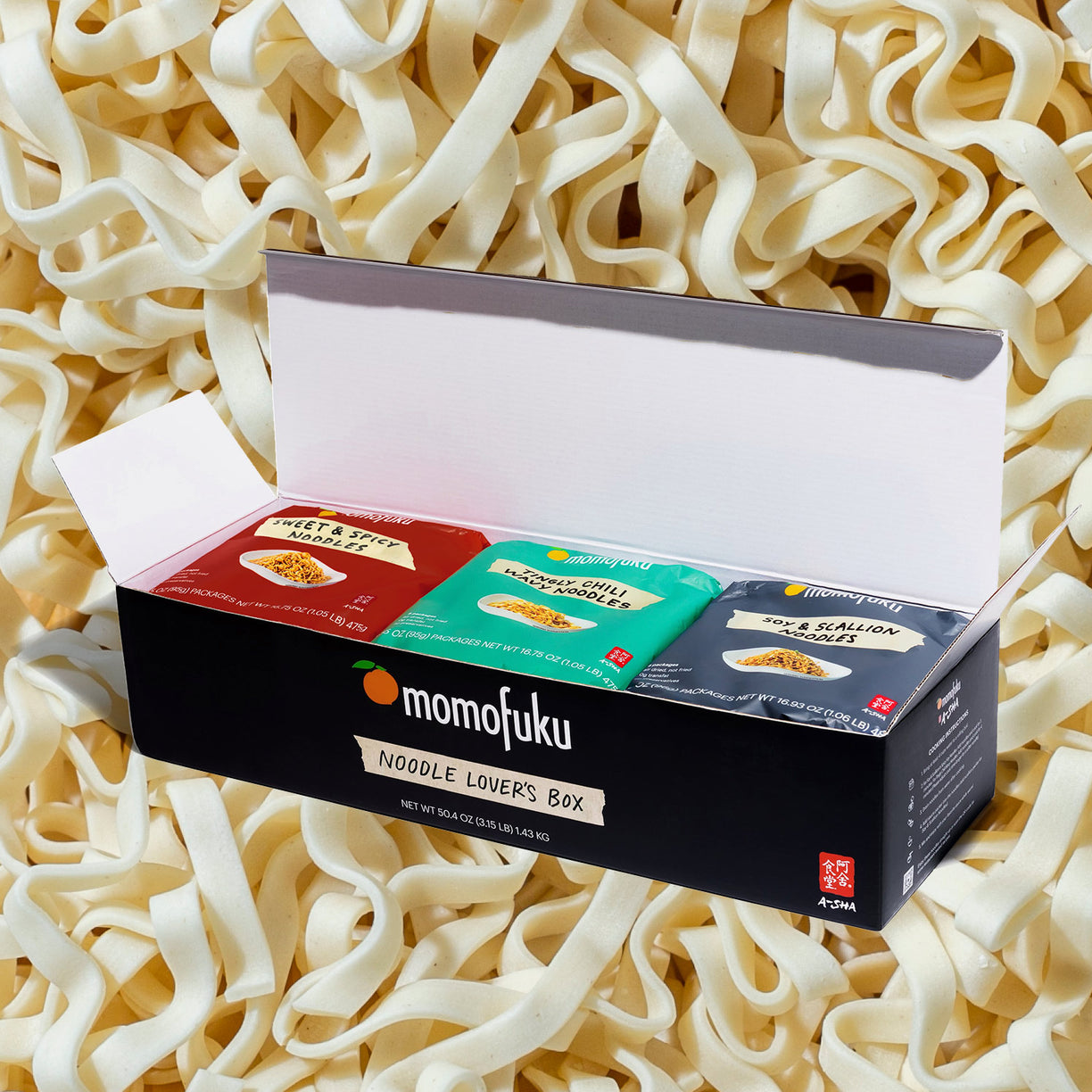 sweet & spicy, tingly chili, and soy & scallion noodles in cardboard box with dried noodle background