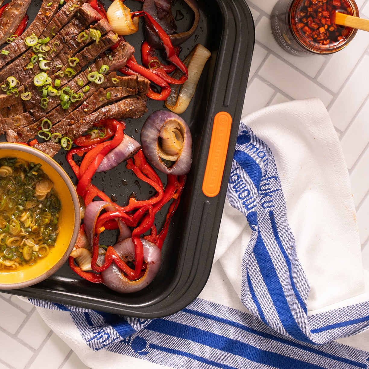 sheet pan with skirt steak and kitchen towel